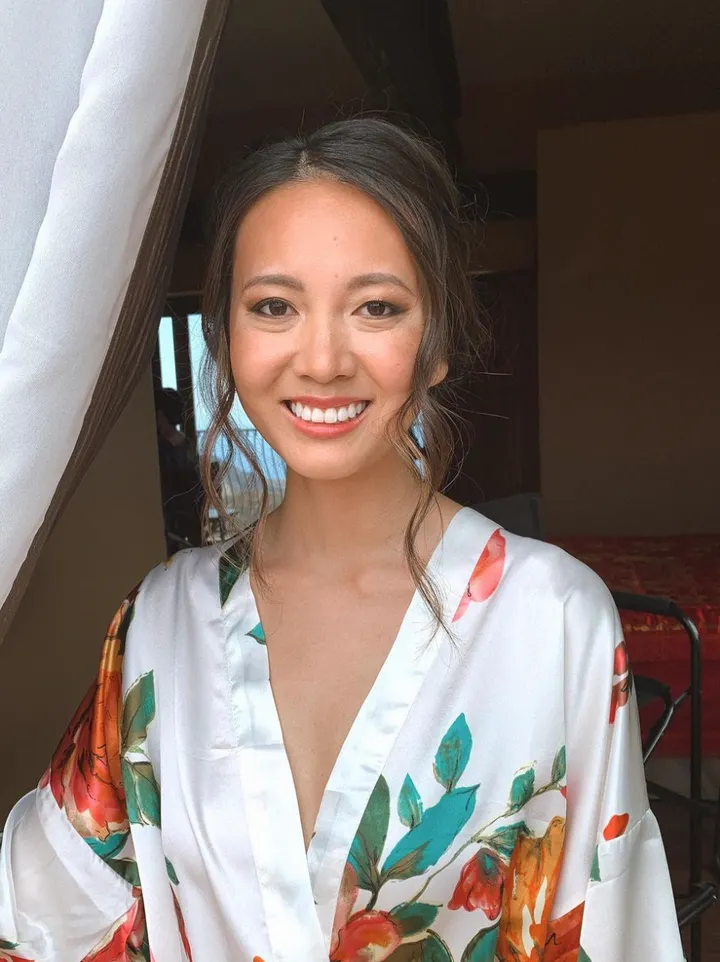 Bride absolutely glowing with fresh, modern makeup look and romantic loose updo hairstyle.