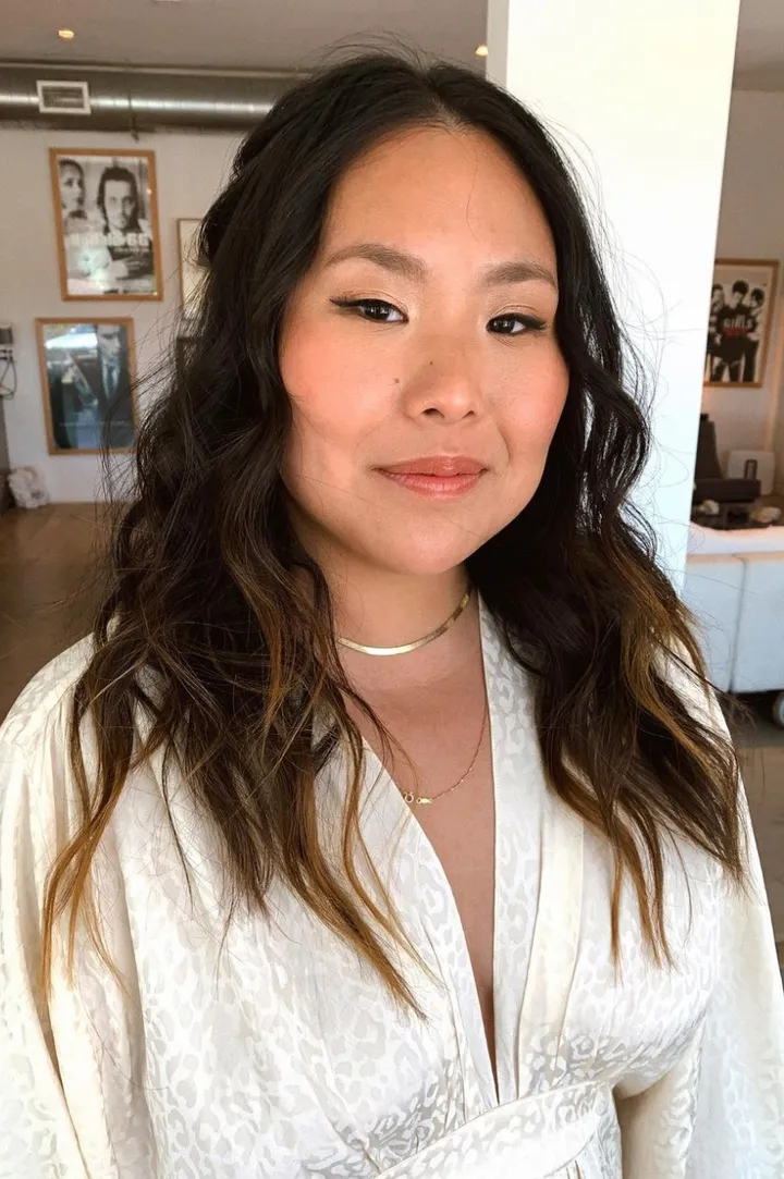 A bride with long, wavy, dark hair and natural airbrushed makeup. The bride is getting married in Joshua Tree at an estate.