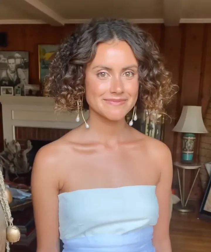 Bride wears strapless dress with curly wedding day hairstyle. Wedding location is on Coronado Island in San Diego county.