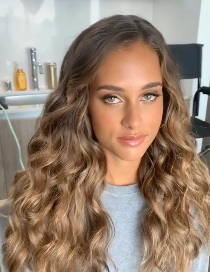 Curly and wavy hairstyle for model during commercial photoshoot.
