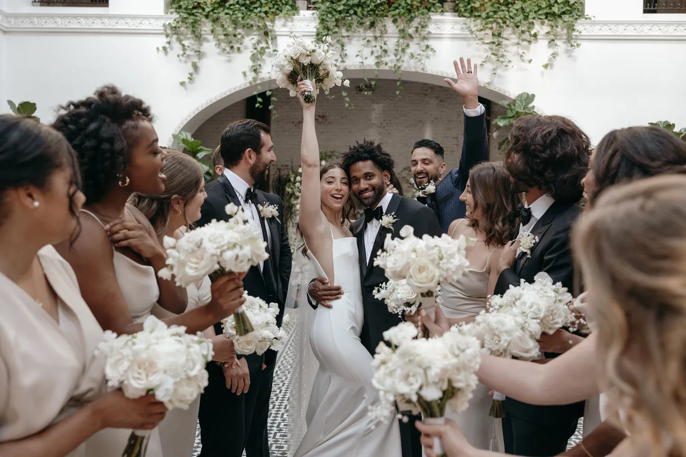 A wedding celebration with a bride and groom in the center, surrounded by friends and fami