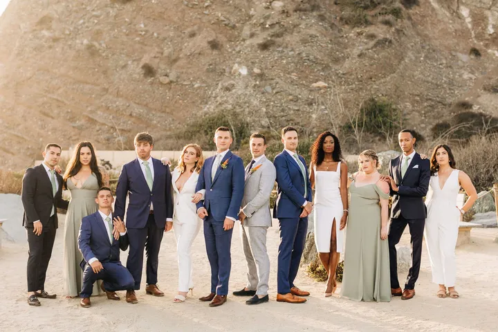 Full wedding party dressed in formal attire standing outdoors in Dana Point.