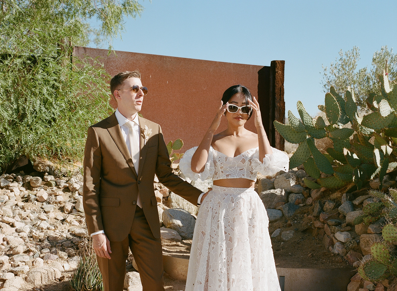 Desert couple in sunglasses among the cacti