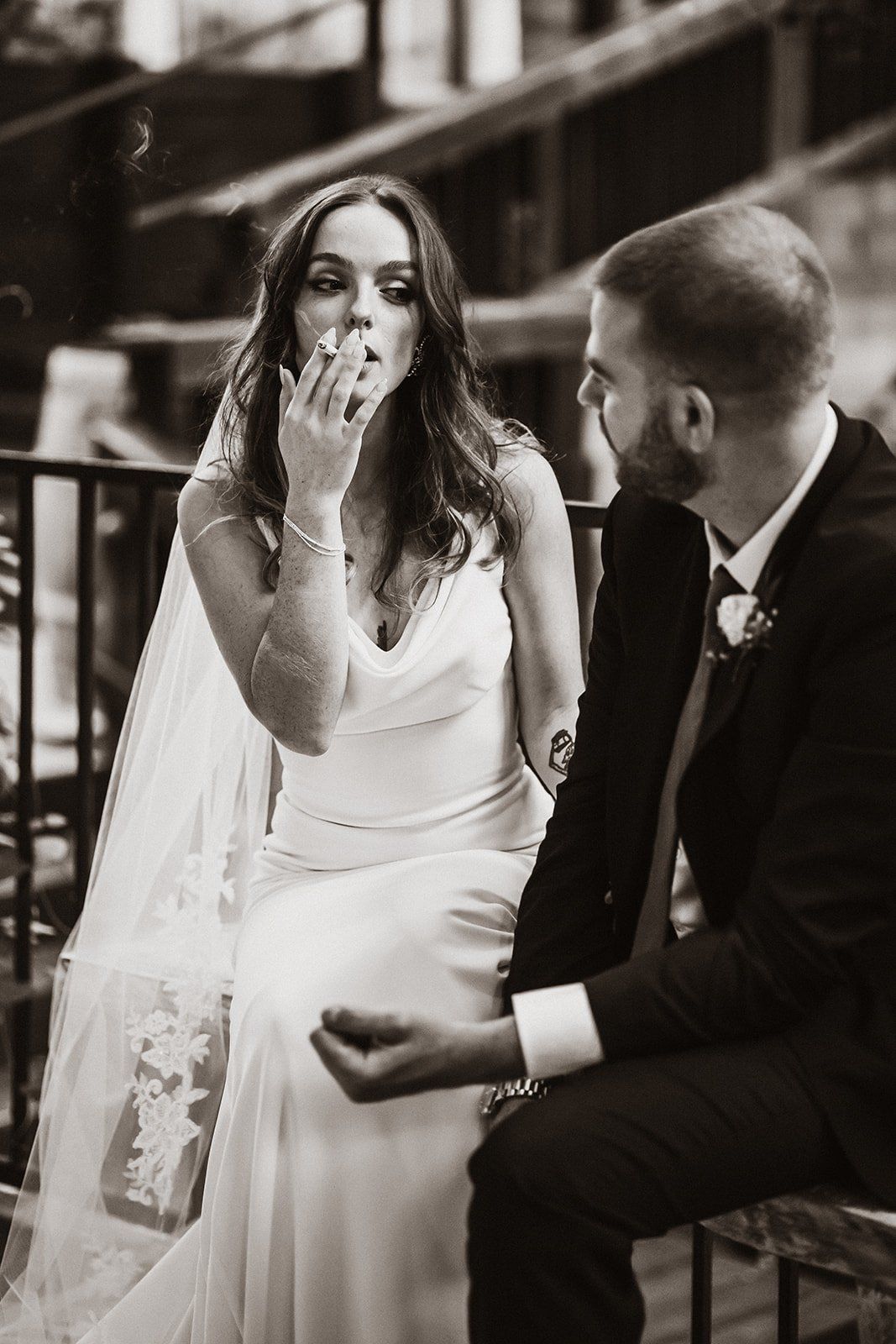bride and groom take a smoke break on their wedding day