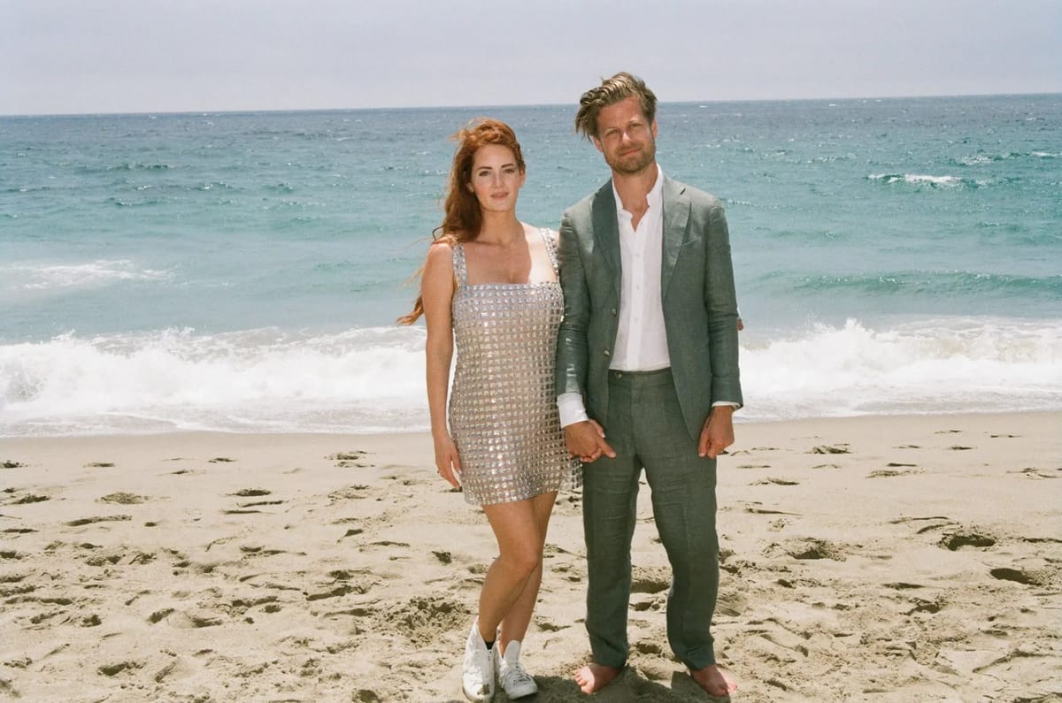 bride and groom in second after-ceremony wedding looks on the beach in malibu, CA