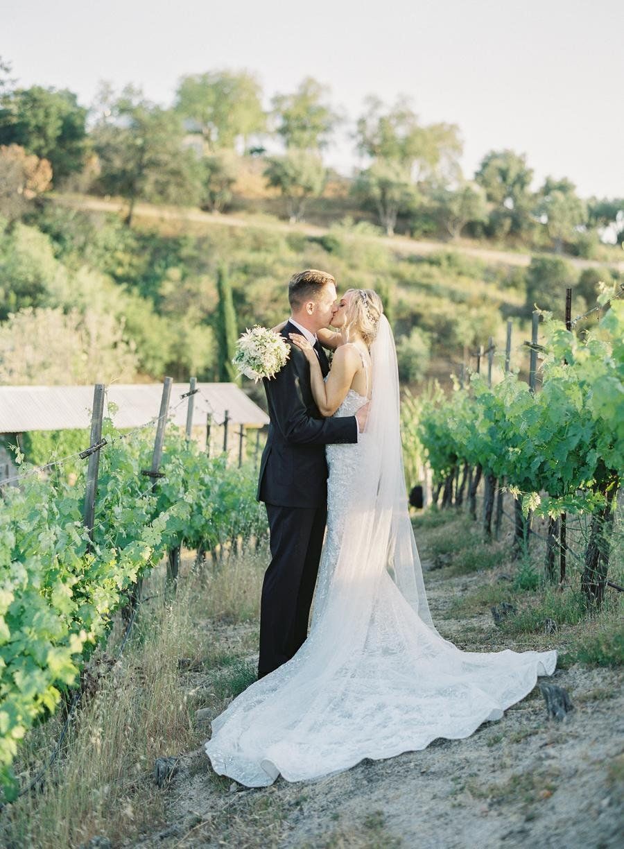 bride and groom take wedding day photos in vineyard on their malibu venue's property