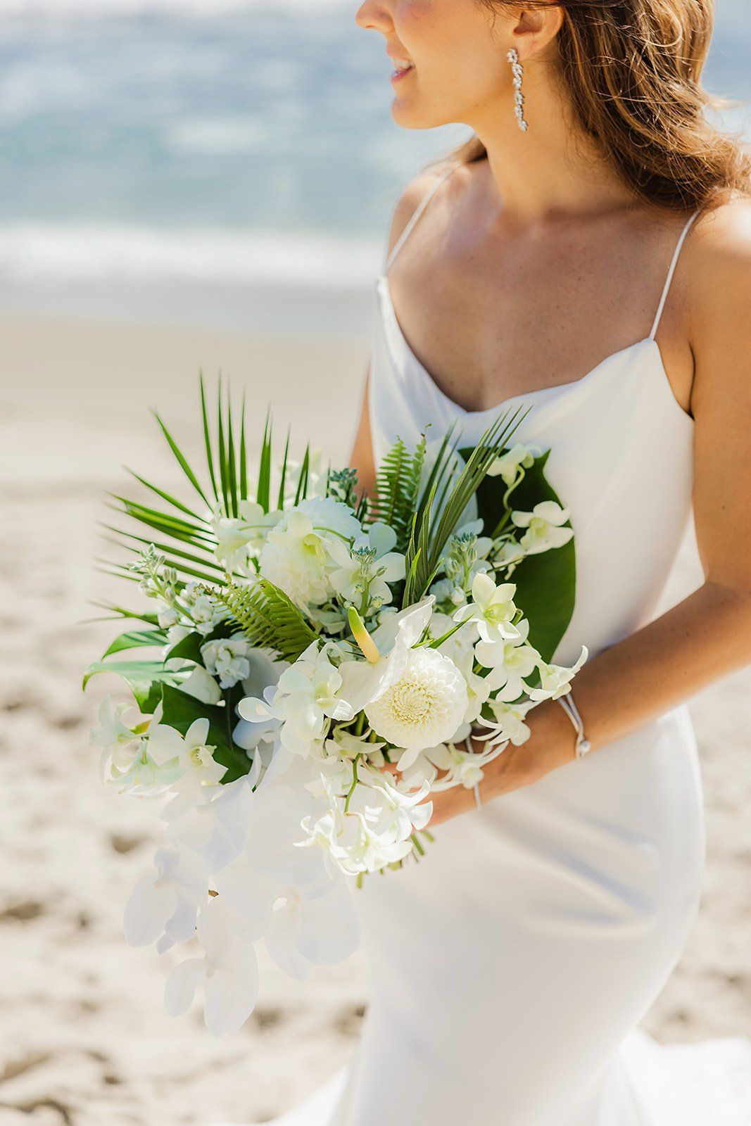 bride carries tropical bouquet for her laguna beach coastal wedding on PCH