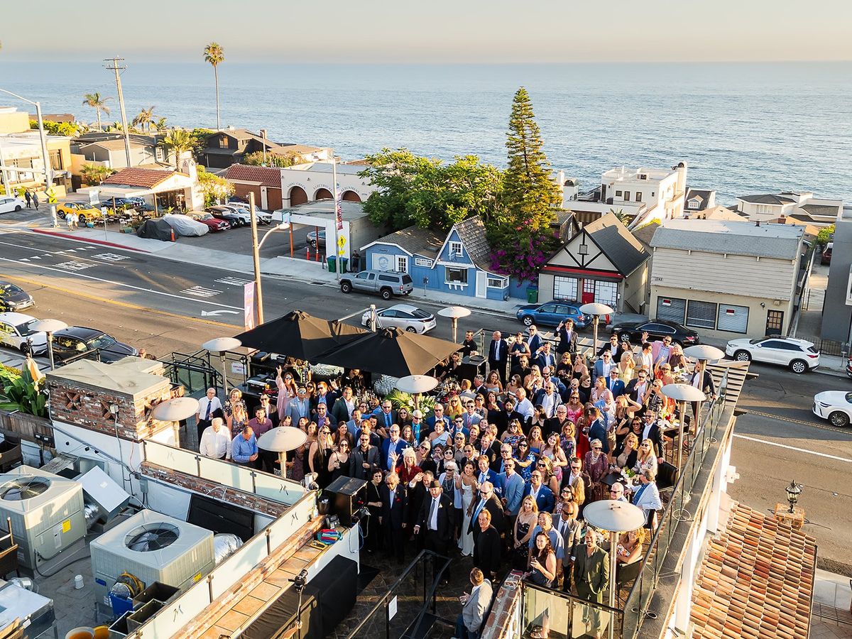 wedding guests enjoy cocktails on the rooftop at laguna beach wedding reception
