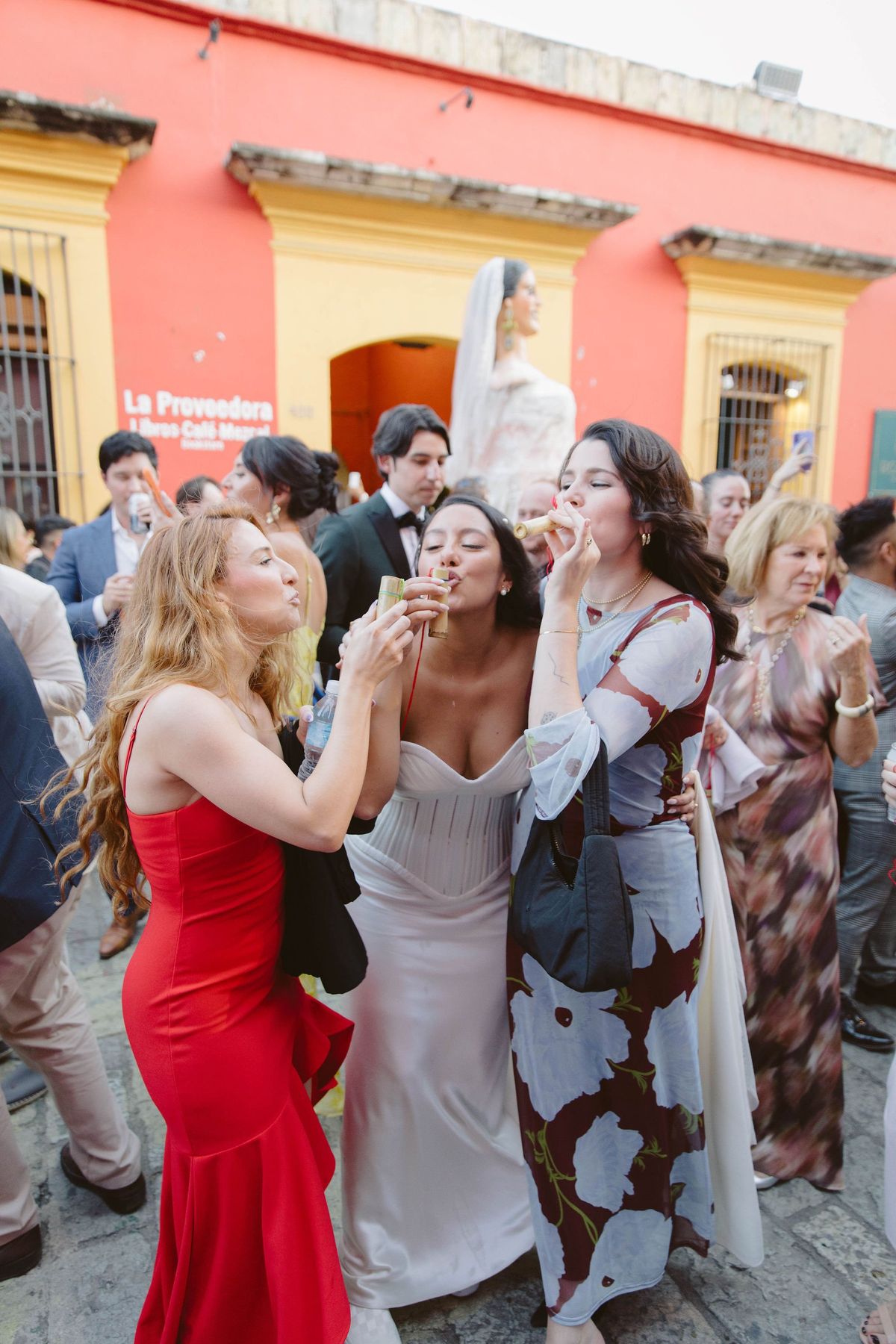 bride takes shots of mezcal while dancing in the streets of oaxaca
