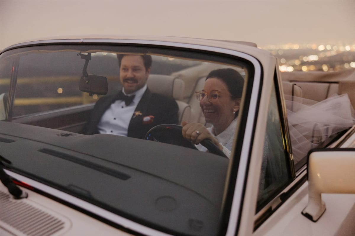 iconic couple driving through hollywood hills in vintage rolls royce after their elopement in Los Angeles