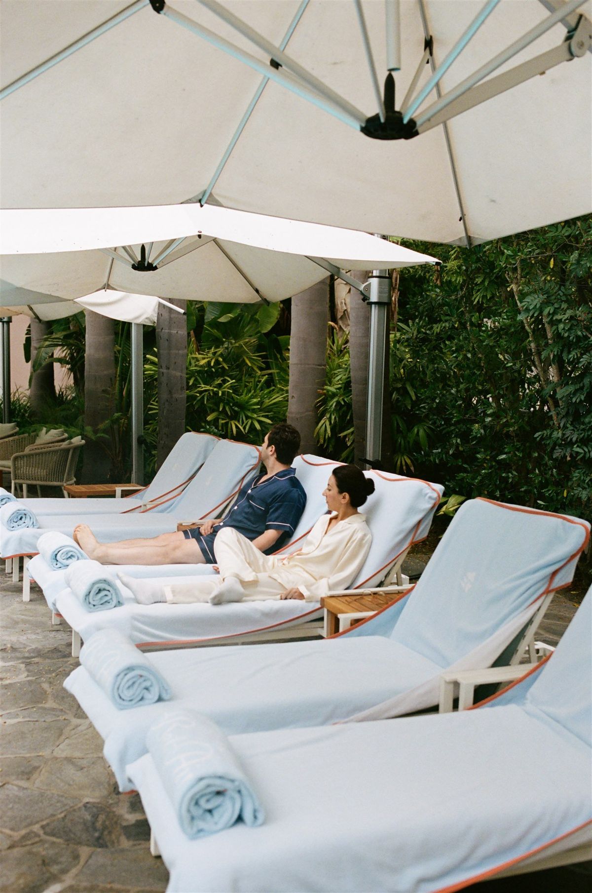 bride and groom lounge by the pool on the morning of their wedding at iconic hotel bel air