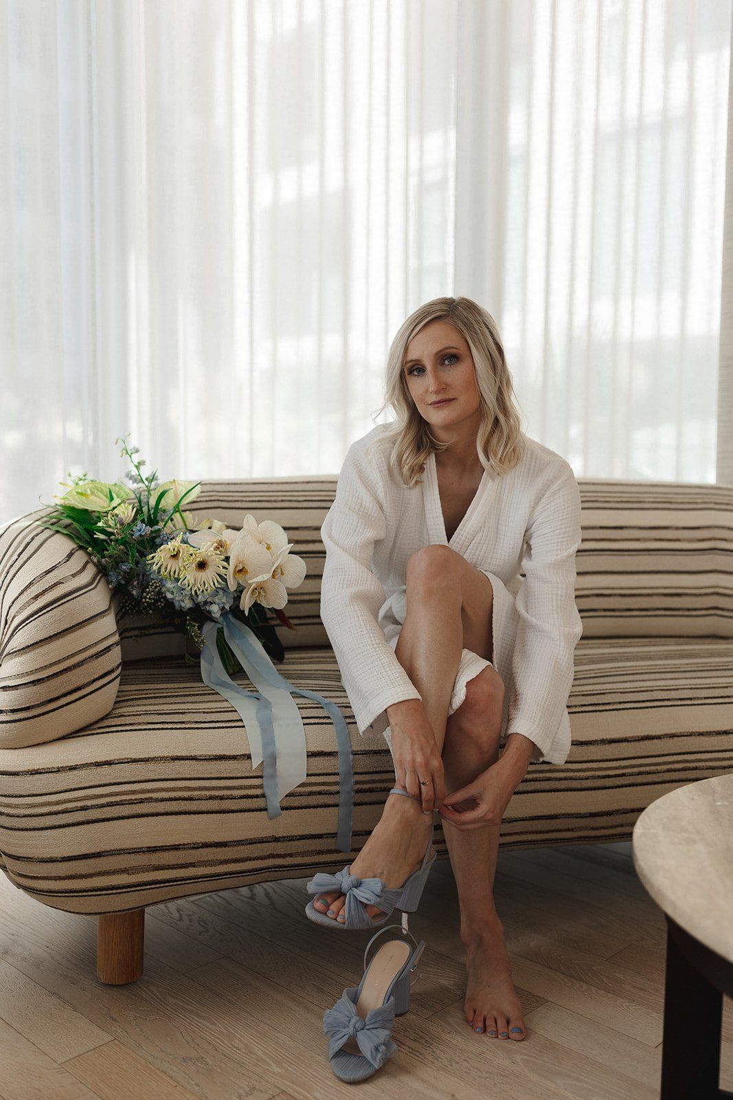 bride puts her shoes on before her destination elopement in LA