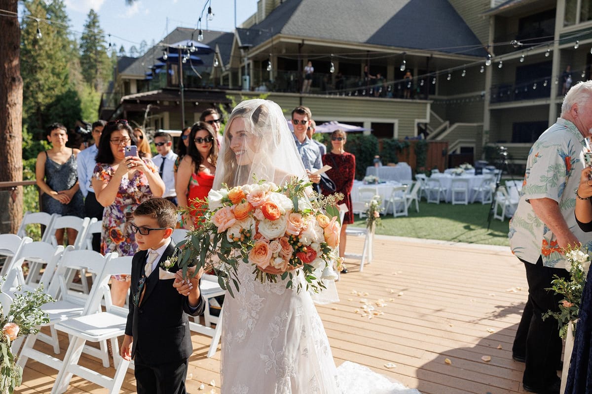 bride walks down the aisle on her wedding day with her son