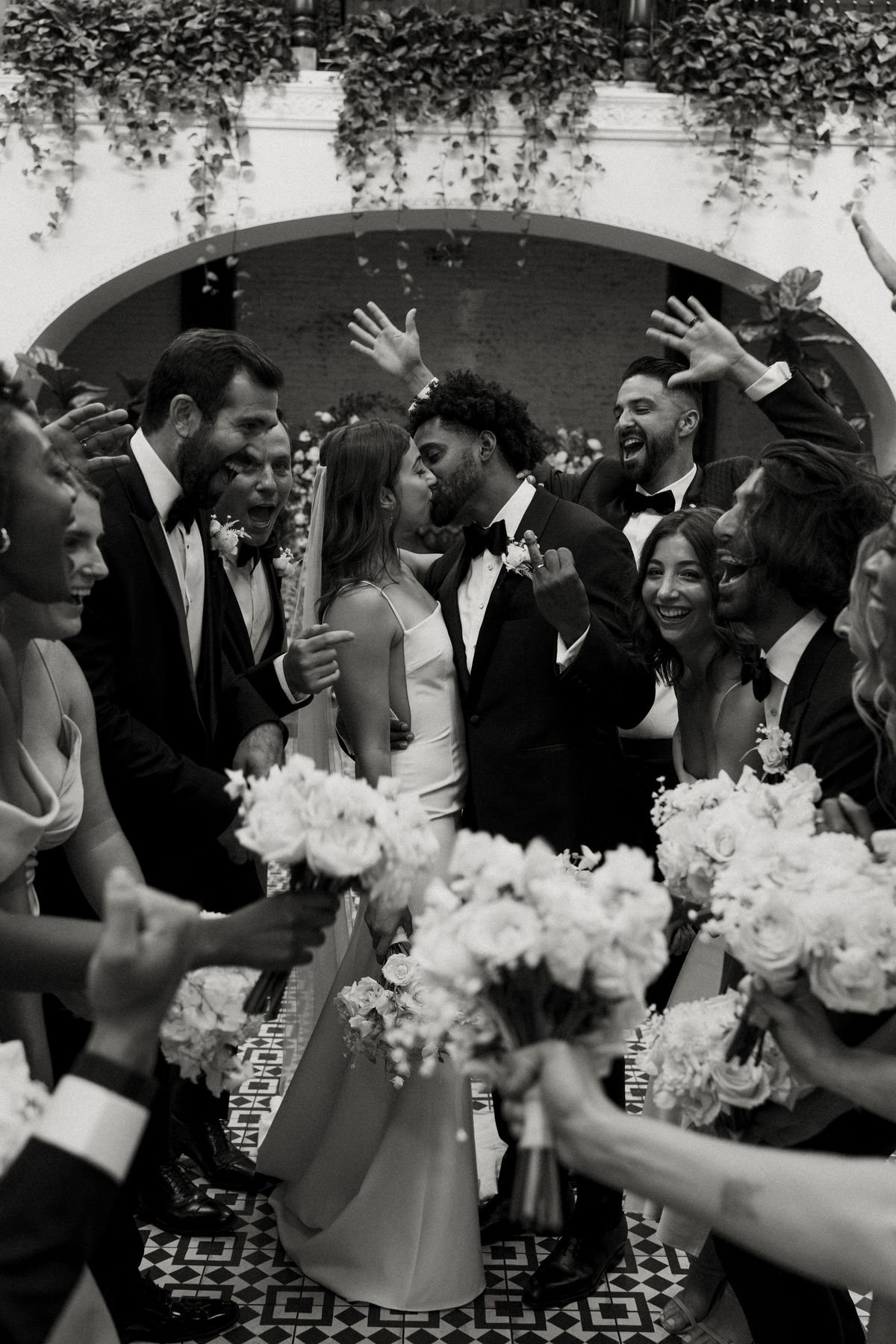bride and groom pose for photos with their bridal party at the ebell of long beach