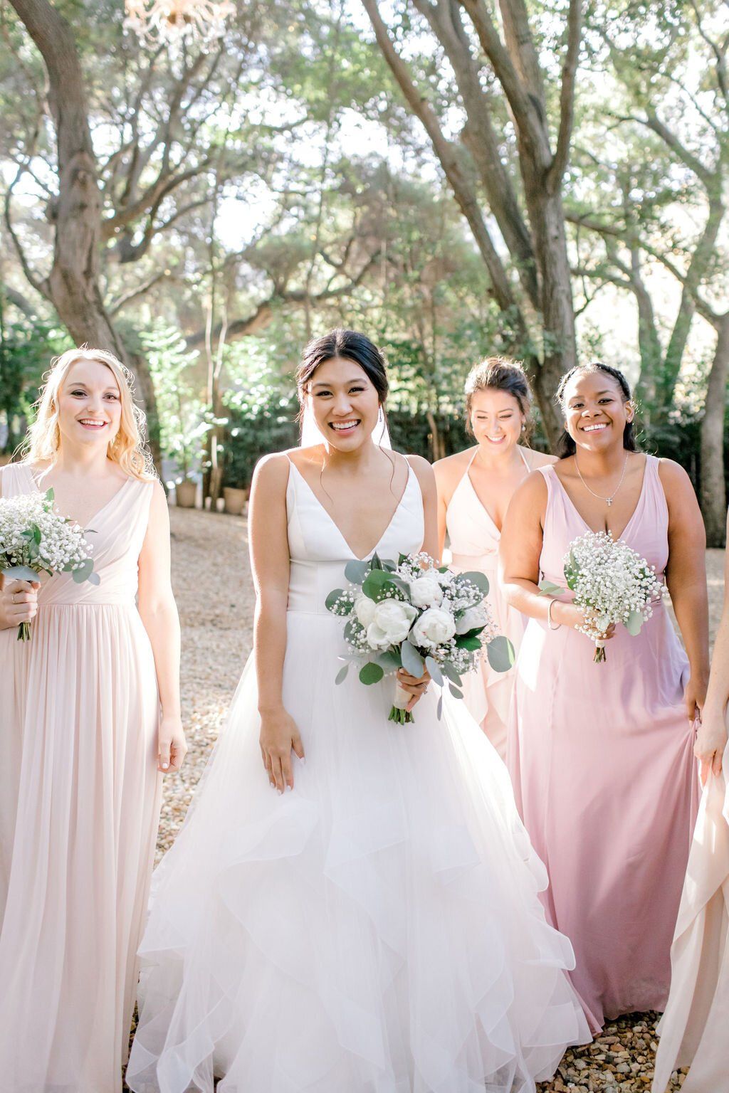 bride and bridal party hair and makeup ready walking towards malibu wedding ceremony