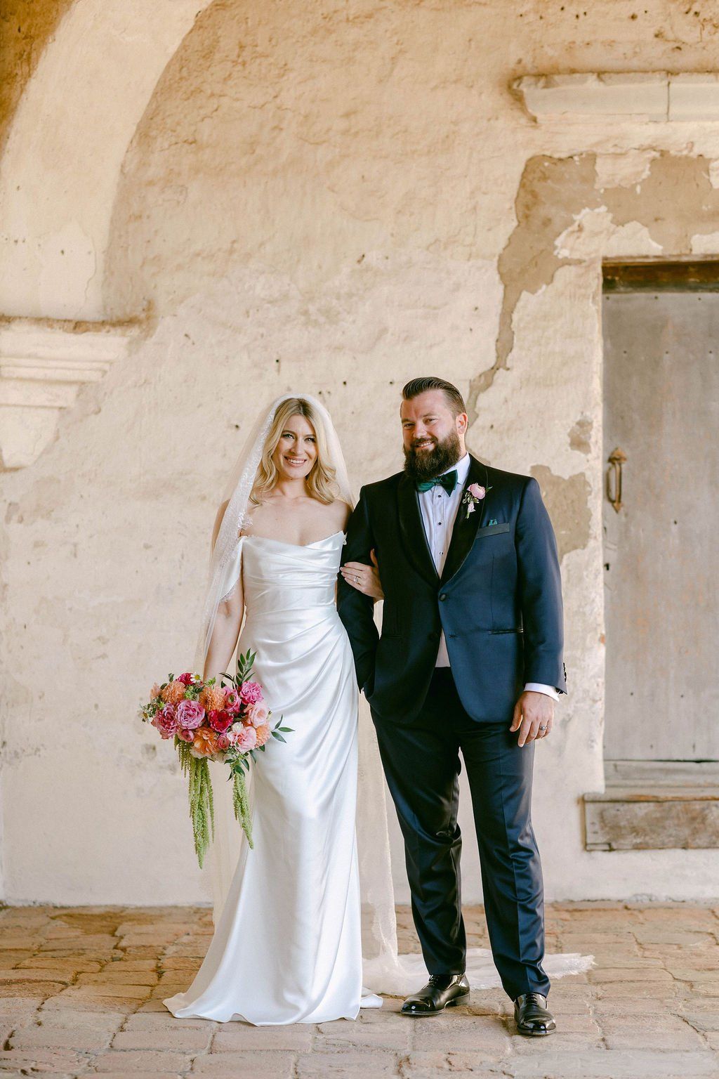 bride and groom take wedding day portraits inside the mission in san juan capistrano
