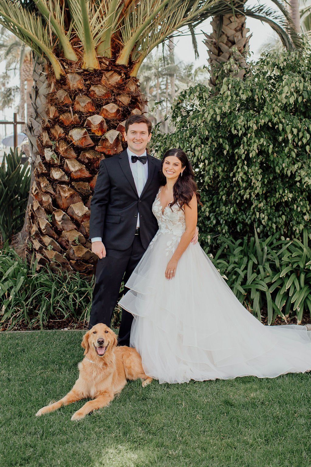 bride and groom pose for photos with their dog