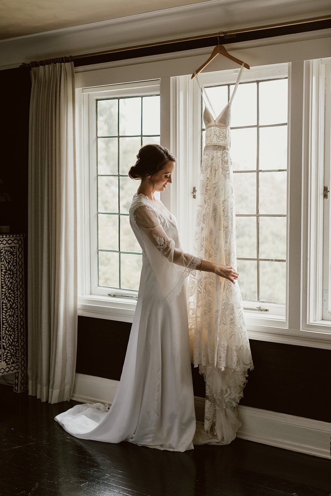 bride looking at her grace loves lace gown