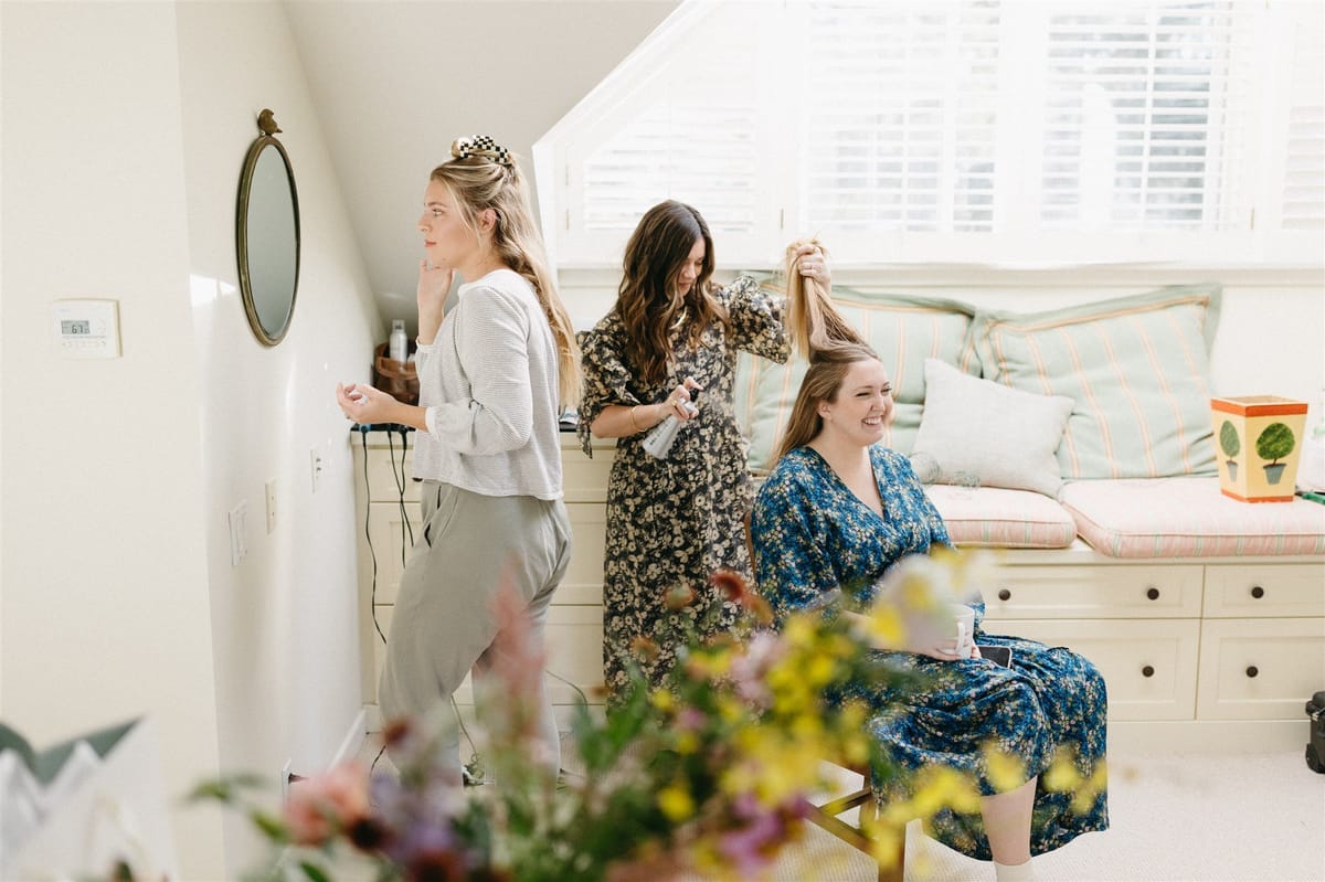 bride getting ready on her wedding day with hair stylist in la canada