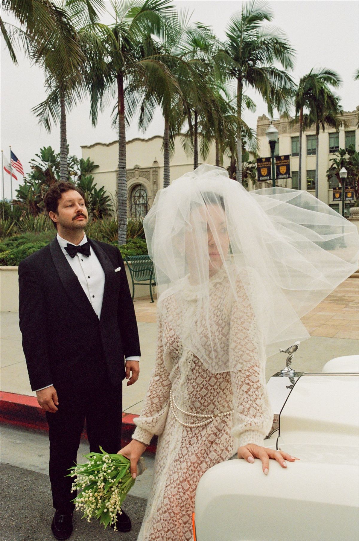 bride's veil blowing in the wind outside of the beverly hills courthouse steps