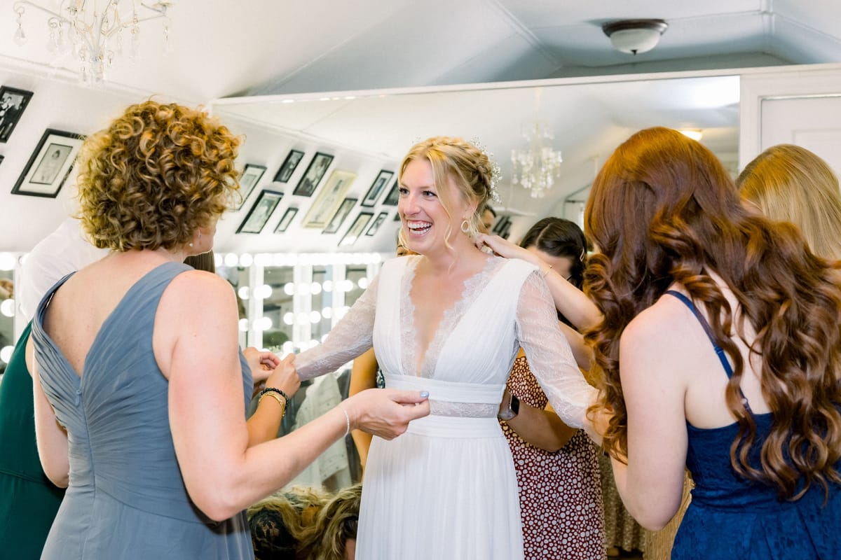 bride getting excited as she puts on her wedding gown